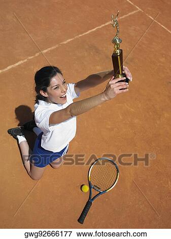 High angle view of a female tennis player jumping with a trophy View Large Photo Image Stock Photo - High angle view of a female tennis player jumping with a trophy. Fotosearch