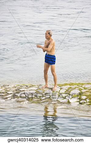 Stock Photography - High angle view of a senior man standing at the riverside, Guilin, Guangxi Province, China. Fotosearch