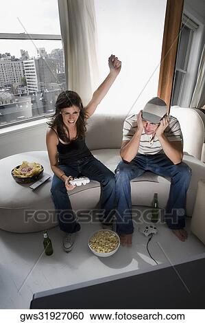 High angle view of a young couple playing video game View Large Photo Image Stock Image - High angle view of a young couple playing video game. Fotosearch