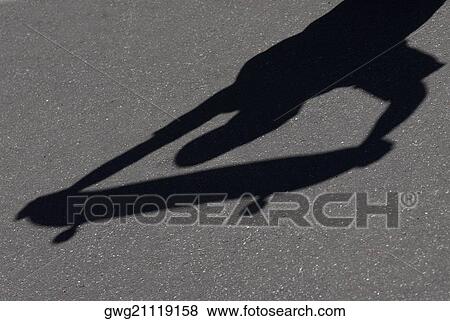 High angle view of shadow of a person holding a skateboard View Large Photo Image Stock Photo - High angle view of shadow of a person holding a skateboard. Fotosearch