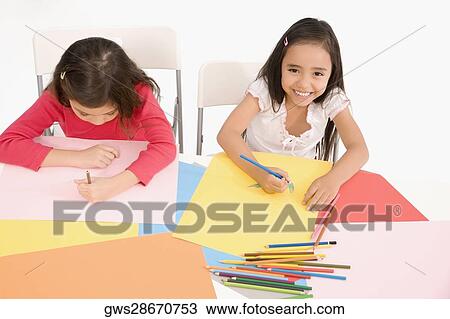 High angle view of two girls drawing in a classroom View Large Photo Image Stock Image - High angle view of two girls drawing in a classroom. Fotosearch