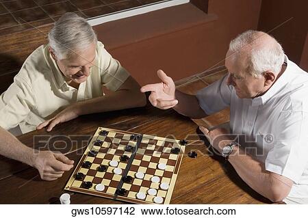 High angle view of two senior men playing checkers View Large Photo Image Stock Image - High angle view of two senior men playing checkers. Fotosearch