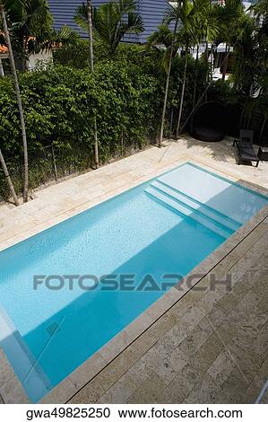 Stock Image - Lounge chairs at the poolside. Fotosearch