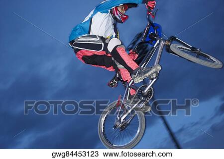 Low angle view of a BMX cyclist performing in mid-air View Large Photo Image Stock Image - Low angle view of a BMX cyclist performing in mid-air. Fotosearch