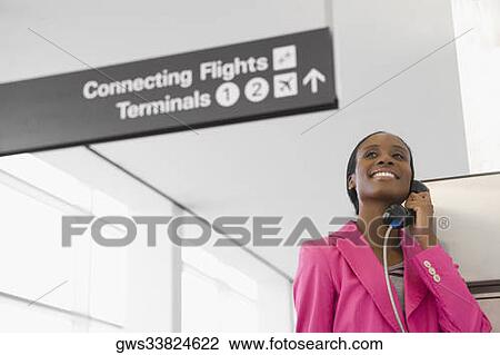 Low angle view of a businesswoman talking on a pay phone at an airport View Large Photo Image Stock Image - Low angle view of a businesswoman talking on a pay phone at an airport. Fotosearch