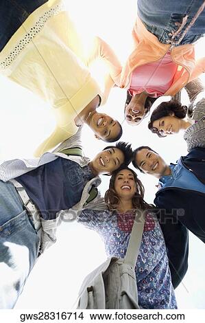 Picture - Low angle view of a group of friends smiling. Fotosearch
