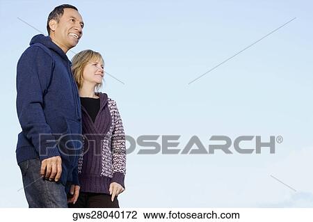 Low angle view of a mature couple standing and smiling View Large Photo Image Stock Image - Low angle view of a mature couple standing and smiling. Fotosearch