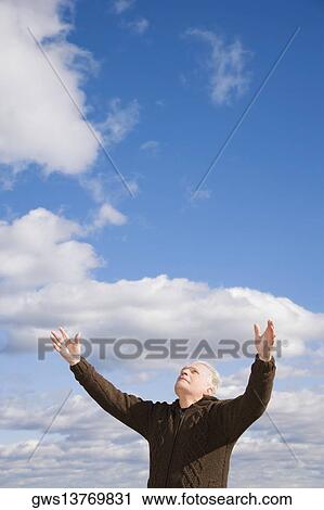 Low angle view of a senior man standing with his arms raised View Large Photo Image Stock Image - Low angle view of a senior man standing with his arms raised. Fotosearch