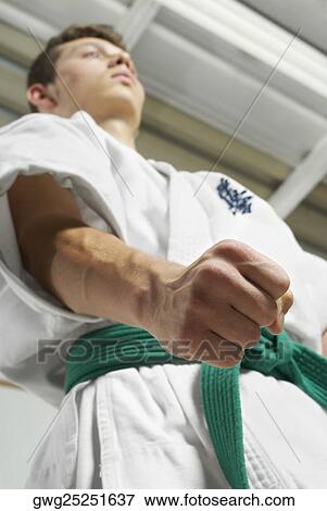 Stock Photo - Low angle view of a young man practicing karate. Fotosearch