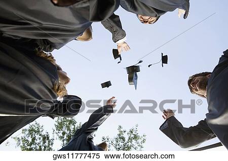 Stock Photography - Low angle view of graduate students throwing their mortar boards in air. Fotosearch