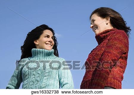Low angle view of two mature women standing together and smiling View Large Photo Image Stock Photo - Low angle view of two mature women standing together and smiling. Fotosearch