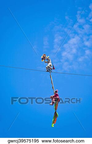 Stock Photography - Low angle view of two people performing stunt on a rope, Emerald Valley, Huangshan, Anhui Province, China. Fotosearch