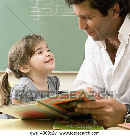 Male teacher teaching his student in a classroom View Large Photo Image Stock Photo - Male teacher teaching his student in a classroom. Fotosearch