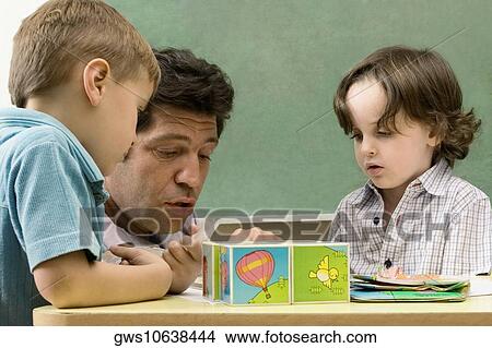 Male teacher teaching his students in a classroom View Large Photo Image Picture - Male teacher teaching his students in a classroom. Fotosearch