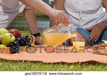 Man pouring juice into a glass View Large Photo Image Stock Photo - Man pouring juice into a glass. Fotosearch