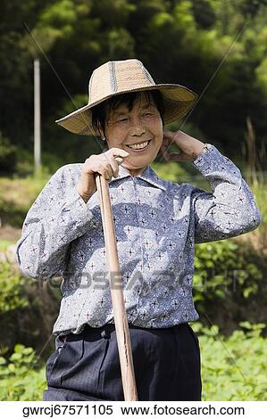 Stock Photography - Mature woman holding a stick, Emerald Valley, Huangshan, Anhui Province, China. Fotosearch