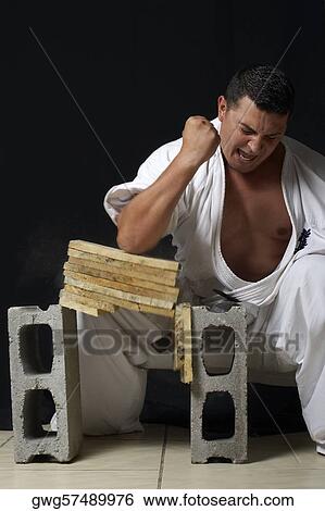 Mid adult man breaking a stack of woods with his elbow View Large Photo Image Stock Photograph - Mid adult man breaking a stack of woods with his elbow. Fotosearch