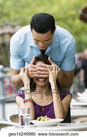 Mid adult man covering eyes of a young woman with his hands View Large Photo Image Stock Photography - Mid adult man covering eyes of a young woman with his hands. Fotosearch