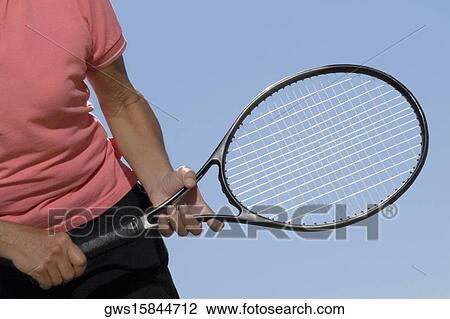 Mid section view of a woman holding a tennis racket View Large Photo Image Stock Image - Mid section view of a woman holding a tennis racket. Fotosearch
