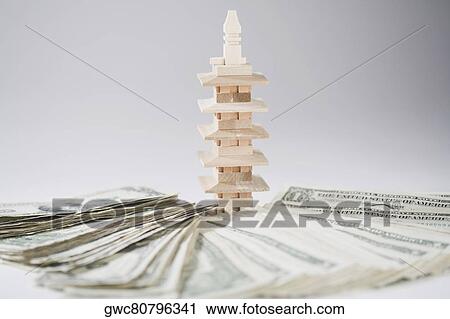 Miniature building with a pile of US paper currency View Large Photo Image Stock Image - Miniature building with a pile of US paper currency. Fotosearch