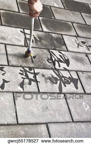 Stock Photo - Person's hand calligraphing on paving stone, Temple of Heaven, Beijing, China. Fotosearch