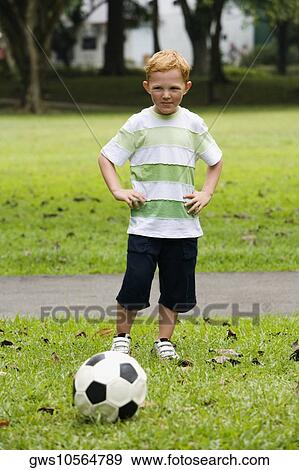 Portrait of a boy playing soccer in a park View Large Photo Image Stock Photo - Portrait of a boy playing soccer in a park. Fotosearch