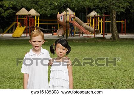 Portrait of a boy standing with a girl in a park View Large Photo Image Stock Photo - Portrait of a boy standing with a girl in a park. Fotosearch
