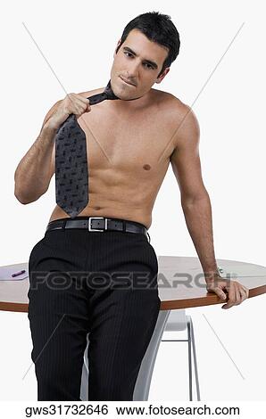 Stock Photograph - Portrait of a businessman leaning against a table. Fotosearch