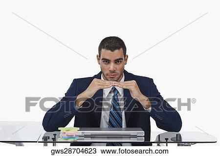Portrait of a businessman sitting at a desk and gesturing View Large Photo Image Stock Image - Portrait of a businessman sitting at a desk and gesturing. Fotosearch