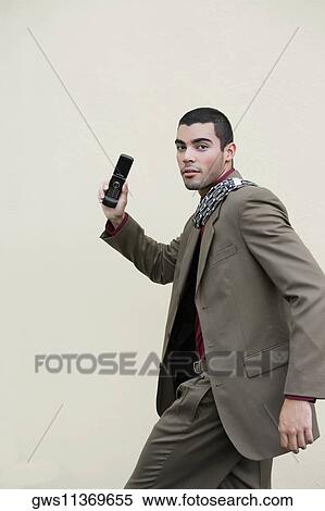 Stock Photography - Portrait of a businessman walking with a mobile phone. Fotosearch
