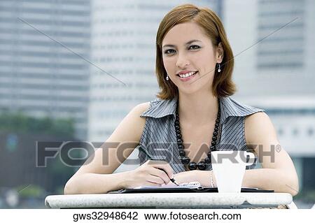 Stock Image - Portrait of a businesswoman at a sidewalk cafe. Fotosearch