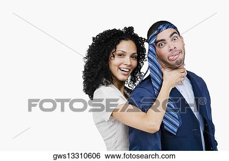Stock Photograph - Portrait of a businesswoman pretending to strangulate a businessman. Fotosearch
