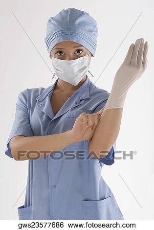 Stock Photograph - Portrait of a female surgeon holding a syringe. Fotosearch