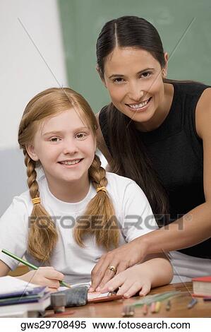 Portrait of a female teacher teaching a schoolgirl in a classroom View Large Photo Image Stock Photography - Portrait of a female teacher teaching a schoolgirl in a classroom. Fotosearch