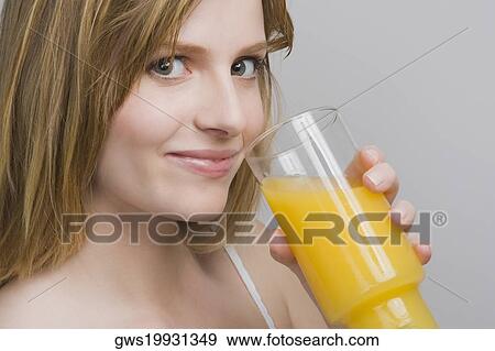 Stock Photo - Portrait of a teenage girl drinking a glass of orange juice. Fotosearch