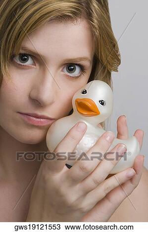 Stock Image - Portrait of a teenage girl holding a rubber duck. Fotosearch