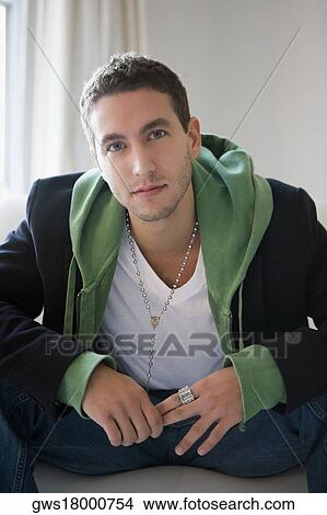Portrait of a young man sitting on a couch View Large Photo Image Picture - Portrait of a young man sitting on a couch. Fotosearch
