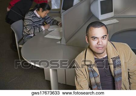 Portrait of a young man with another young man sitting behind him View Large Photo Image Stock Image - Portrait of a young man with another young man sitting behind him. Fotosearch