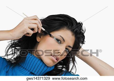 Portrait of a young woman applying eyeshadow View Large Photo Image Stock Photo - Portrait of a young woman applying eyeshadow. Fotosearch