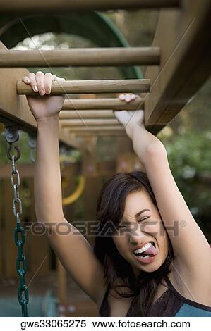Portrait of a young woman hanging on monkey bars View Large Photo Image Stock Photography - Portrait of a young woman hanging on monkey bars. Fotosearch