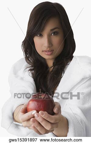 Portrait of a young woman holding an apple View Large Photo Image Stock Photo - Portrait of a young woman holding an apple. Fotosearch