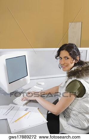 Portrait of a young woman working on a computer and smiling View Large Photo Image Stock Image - Portrait of a young woman working on a computer and smiling. Fotosearch