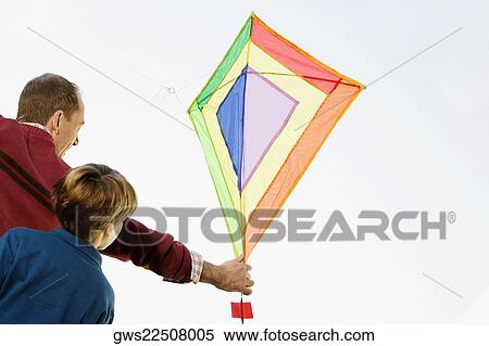 Rear view of a mid adult man with his son flying a kite View Large Photo Image Stock Photography - Rear view of a mid adult man with his son flying a kite. Fotosearch