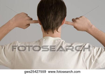 Rear view of a young man with his fingers in his ears View Large Photo Image Stock Photo - Rear view of a young man with his fingers in his ears. Fotosearch
