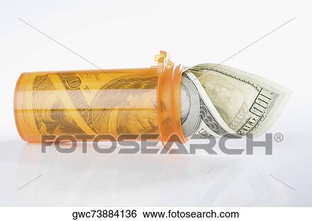 Stock Photograph - Roll of US one hundred dollar bills inside a pill bottle. Fotosearch