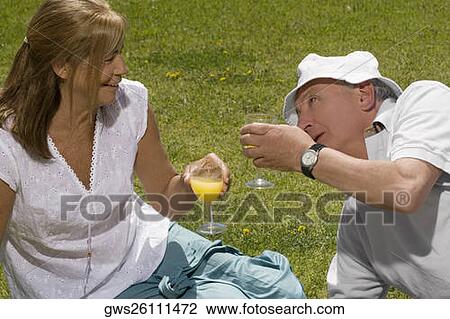 Senior couple holding glasses of juice and smiling View Large Photo Image Stock Image - Senior couple holding glasses of juice and smiling. Fotosearch