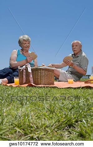 Senior couple playing cards at picnic View Large Photo Image Stock Image - Senior couple playing cards at picnic. Fotosearch