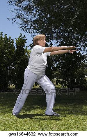 Stock Image - Senior woman exercising in a garden. Fotosearch