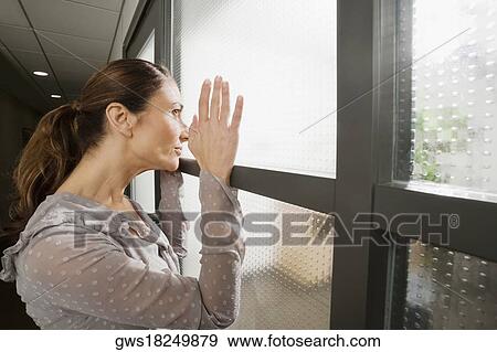 Side profile of a businesswoman looking through a window View Large Photo Image Stock Photo - Side profile of a businesswoman looking through a window. Fotosearch