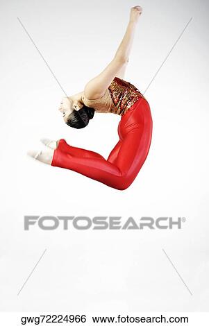 Stock Photograph - Side profile of a female gymnast jumping. Fotosearch